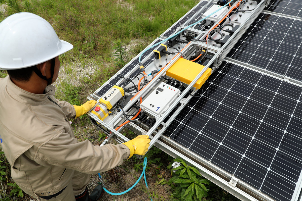 太陽光パネル洗浄機を操作する専門作業員