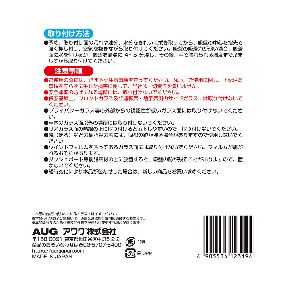 台紙裏面の右側。取り付け方法は、取り付け面を拭き取り、吸盤の中心を押し付けて空気を抜く。吸着力が弱いときは水を付けるか熱湯に4〜5分浸して冷ましてから貼る。注意事項として、安全運転の妨げになる場所には取り付けないこと、経時劣化で色あせた場合は新しい商品に取り替えることなど。アウグ株式会社の連絡先と MADE IN JAPAN の表示