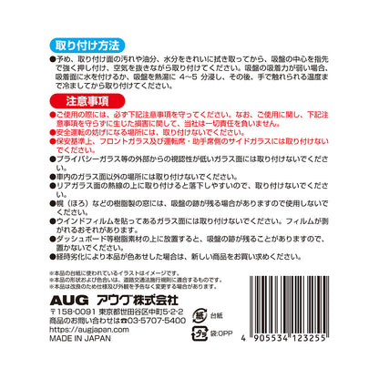台紙裏面の右側。取り付け方法は、取り付け面を拭き取り、吸盤の中心を押し付けて空気を抜く。吸着力が弱いときは水を付けるか熱湯に4〜5分浸して冷ましてから貼る。注意事項として、安全運転の妨げになる場所には取り付けないこと、経時劣化で色あせた場合は新しい商品に取り替えることなど。アウグ株式会社の連絡先と MADE IN JAPAN の表示