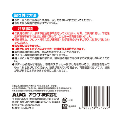 台紙裏面の右側。取り付け方法は、取り付け面を拭き取り、平らな面に貼る。貼り直しはできず、ボディに跡が残る場合がある。注意事項として、安全運転の妨げになる場所には取り付けないこと、経時劣化で色あせた場合は新しい商品に取り替えることなど。アウグ株式会社の連絡先と MADE IN JAPAN の表示