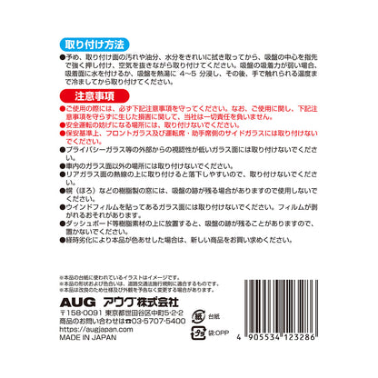 台紙裏面の右側。取り付け方法は、取り付け面を拭き取り、吸盤の中心を押し付けて空気を抜く。吸着力が弱いときは水を付けるか熱湯に4〜5分浸して冷ましてから貼る。注意事項として、安全運転の妨げになる場所には取り付けないこと、経時劣化で色あせた場合は新しい商品に取り替えることなど。アウグ株式会社の連絡先と MADE IN JAPAN の表示